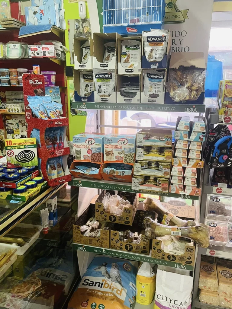 Estante con snacks, alimentos y arena para mascotas, disponible en tienda de alimentación y accesorios para mascotas en Atarfe